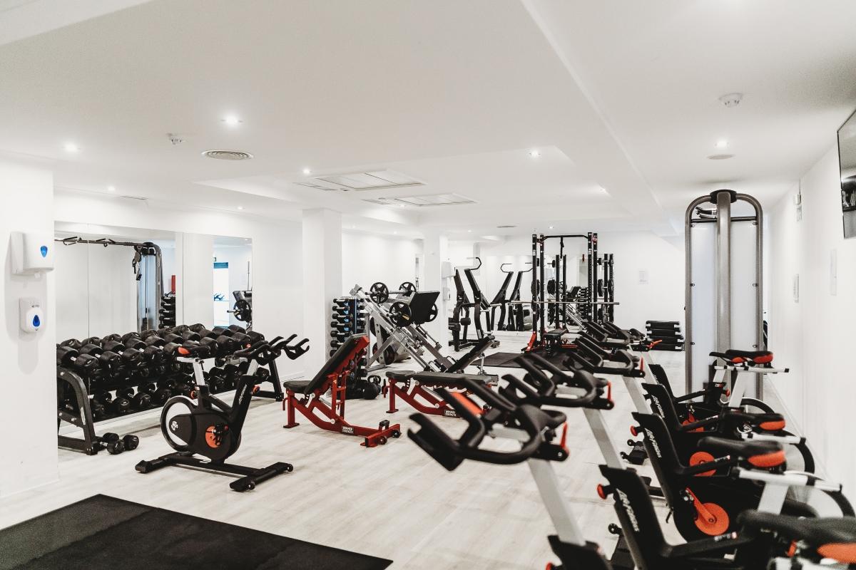 white interior of gym in Dubai with white walls and workout machines