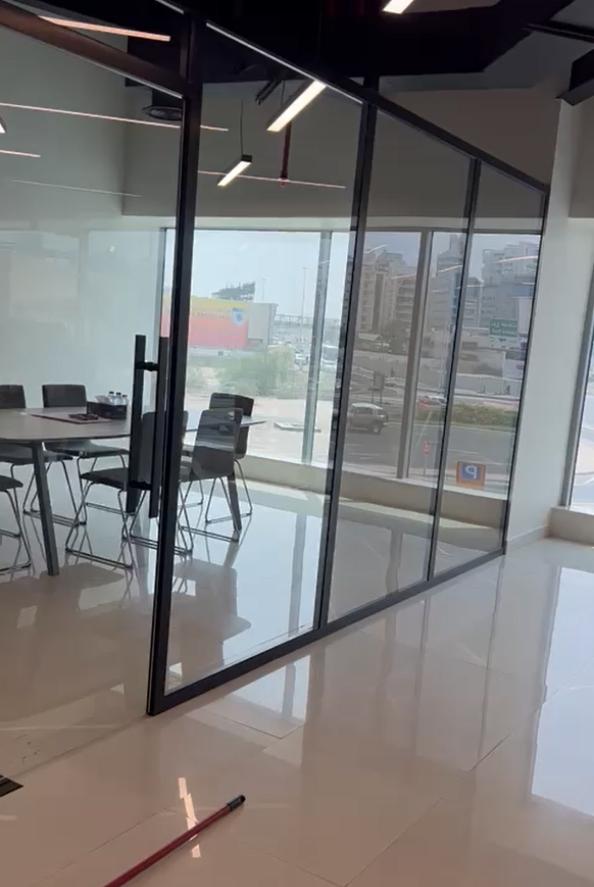 Glass partition of an office with black chairs placed inside